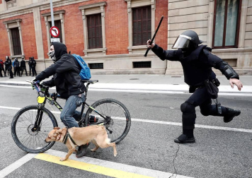 Efectivos de la Policía Nacional disuelven una concentración que han llevado a cabo un centenar de jóvenes junto al Parlamento de Navarra donde han acudido para protestar por la intervención de la Policía Foral esta madrugada en el palacio del Marqués de Rozalejo.