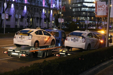 Varios taxis han comenzado a ser retirados por grúas en el paseo de la Castellana de Madrid donde los taxistas mantienen una concentración en el marco de la huelga del sector