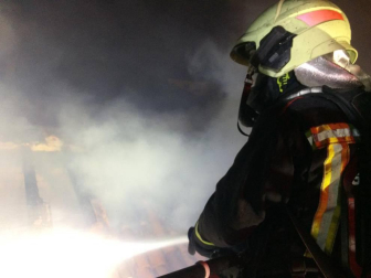 Un bombero apagando el incendio de una vivienda en Alsasua
