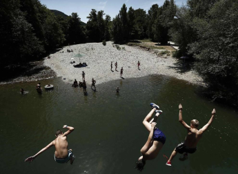 Varias personas se alivian del calor en el pantano de Alloz y en el río Arga a su paso por Irotz.