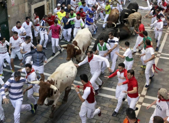 Momentos de tensión cuando el morlaco jabonero de la ganadería de Núñez del Cuvillo perdió pie en la calle Estafeta y cayó al suelo, rodeado de mozos.