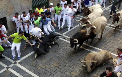 Momentos de tensión cuando el morlaco jabonero de la ganadería de Núñez del Cuvillo perdió pie en la calle Estafeta y cayó al suelo, rodeado de mozos.