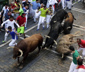 Momentos de tensión cuando el morlaco jabonero de la ganadería de Núñez del Cuvillo perdió pie en la calle Estafeta y cayó al suelo, rodeado de mozos.