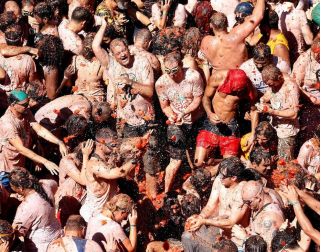Un total de 20.000 personas han disfrutado este miércoles de la 74 edición de la Tomatina en la localidad valenciana de Buñol, donde los aproximadamente 150.000 kilos de tomate distribuidos en siete camiones han teñido de rojo las calles del municipio.