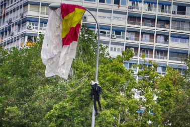 El paracaidista que descendía con la bandera de España que se iza para el desfile de la Fiesta Nacional ha impactado contra una farola del paseo de la Castellana de Madrid, junto al palco de las autoridades, y ha quedado atrapado allí unos minutos.