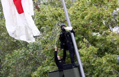 El paracaidista que descendía con la bandera de España que se iza para el desfile de la Fiesta Nacional ha impactado contra una farola del paseo de la Castellana de Madrid, junto al palco de las autoridades, y ha quedado atrapado allí unos minutos.