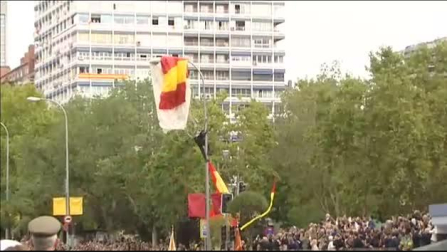 Un paracaidista se queda enganchado a una farola en el desfile del Día de la Hispanidad