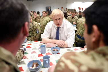 El primer ministro británico sirvió a los soldados una comida prenavideña en la cantina de esa base.