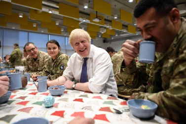 El primer ministro británico sirvió a los soldados una comida prenavideña en la cantina de esa base.