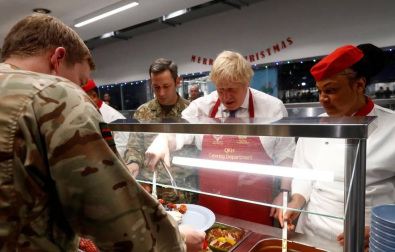 El primer ministro británico sirvió a los soldados una comida prenavideña en la cantina de esa base.