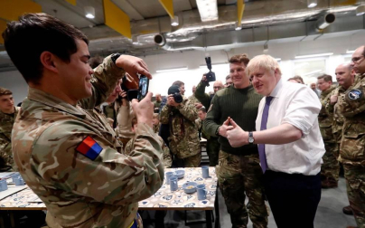 El primer ministro británico sirvió a los soldados una comida prenavideña en la cantina de esa base.