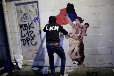 El artista LKN coloca el dibujo en homenaje a Maider Irisarri, anoche en la calle Nueva junto a la plaza San Francisco de Pamplona.