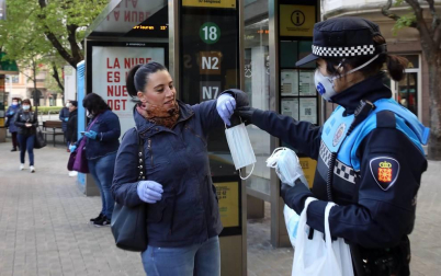 Agentes reparten mascarillas para prevenir el coronavirus en Pamplona.