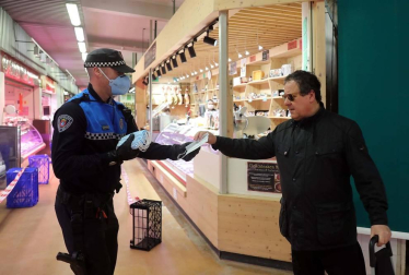 Agentes reparten mascarillas para prevenir el coronavirus en Pamplona.