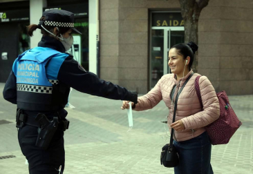 Agentes reparten mascarillas para prevenir el coronavirus en Pamplona.