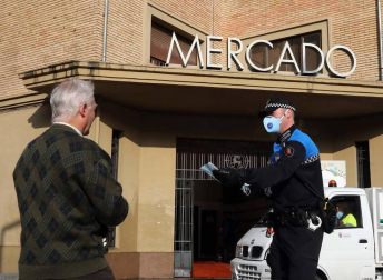Agentes reparten mascarillas para prevenir el coronavirus en Pamplona.