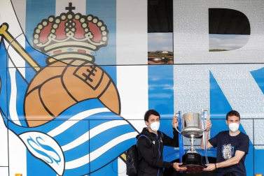 Cientos de aficionados de la Real Sociedad han aguardado en los márgenes de la carretera que conecta el aeropuerto de Hondarribia con San Sebastián para saludar a los campeones de la Copa del Rey.