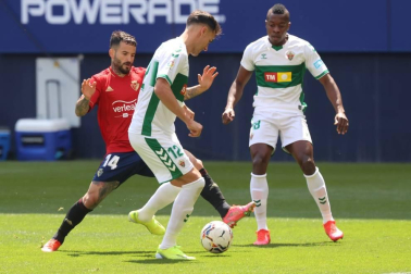 Rubén García pelea por un balón con dos rivales del Elche.
