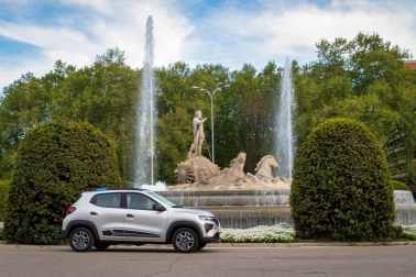 Así es el Dacia Spring, el rey eléctrico de la ciudad. Con solo 3,7 metros de largo, es el vehículo más recomendado para rodar sin emisiones por la ciudad. Su autonomía urbana de 305 kilómetros tienen la culpa, además de su precio, de solo 9.950 euros con el Plan MOVES III incluido. El Seat Mii es su rival más directo. Su tamaño es diminuto, pero destaca su estética SUV de bolsillo.
Como se aprecia en las imágenes, luce pasos de ruedas más anchos, barras de techo, bajos de carrocería delanteros reforzados, protección trasera y distancia al suelo sobreelevada (151 mm en vacío). Tras el logotipo del frontal, con una calandra cerrada al tratarse de un coche eléctrico, se ubica disimuladamente la boca de carga. Las luces LED más afiladas remarcan la línea horizontal de la mirada del Spring. Los embellecedores de este vehículo imitan la estética de las llantas de aleación. Esta apariencia es posible gracias al sistema Flexwheel: las llantas de chapa son abiertas.
Su motor ofrece un potencia de 44 CV, suficiente para rodar por ciudad, dado su bajo peso, de menos de una tonelada. Como curiosidad, no dispone de una palanca de cambios al uso. Ofrece ahora un selector de marcha giratorio con una rueda cromada muy sencilla de utilizar, con 3 posiciones: D (drive), N (neutral) y R (retroceso). A bordo de Dacia Spring se pueden instalar cuatro adultos cómodamente y cuenta con un maletero generoso de casi 300 litros de capacidad.