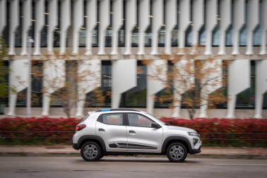 Así es el Dacia Spring, el rey eléctrico de la ciudad. Con solo 3,7 metros de largo, es el vehículo más recomendado para rodar sin emisiones por la ciudad. Su autonomía urbana de 305 kilómetros tienen la culpa, además de su precio, de solo 9.950 euros con el Plan MOVES III incluido. El Seat Mii es su rival más directo. Su tamaño es diminuto, pero destaca su estética SUV de bolsillo.
Como se aprecia en las imágenes, luce pasos de ruedas más anchos, barras de techo, bajos de carrocería delanteros reforzados, protección trasera y distancia al suelo sobreelevada (151 mm en vacío). Tras el logotipo del frontal, con una calandra cerrada al tratarse de un coche eléctrico, se ubica disimuladamente la boca de carga. Las luces LED más afiladas remarcan la línea horizontal de la mirada del Spring. Los embellecedores de este vehículo imitan la estética de las llantas de aleación. Esta apariencia es posible gracias al sistema Flexwheel: las llantas de chapa son abiertas.
Su motor ofrece un potencia de 44 CV, suficiente para rodar por ciudad, dado su bajo peso, de menos de una tonelada. Como curiosidad, no dispone de una palanca de cambios al uso. Ofrece ahora un selector de marcha giratorio con una rueda cromada muy sencilla de utilizar, con 3 posiciones: D (drive), N (neutral) y R (retroceso). A bordo de Dacia Spring se pueden instalar cuatro adultos cómodamente y cuenta con un maletero generoso de casi 300 litros de capacidad.