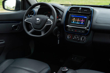 Así es el Dacia Spring, el rey eléctrico de la ciudad. Con solo 3,7 metros de largo, es el vehículo más recomendado para rodar sin emisiones por la ciudad. Su autonomía urbana de 305 kilómetros tienen la culpa, además de su precio, de solo 9.950 euros con el Plan MOVES III incluido. El Seat Mii es su rival más directo. Su tamaño es diminuto, pero destaca su estética SUV de bolsillo.
Como se aprecia en las imágenes, luce pasos de ruedas más anchos, barras de techo, bajos de carrocería delanteros reforzados, protección trasera y distancia al suelo sobreelevada (151 mm en vacío). Tras el logotipo del frontal, con una calandra cerrada al tratarse de un coche eléctrico, se ubica disimuladamente la boca de carga. Las luces LED más afiladas remarcan la línea horizontal de la mirada del Spring. Los embellecedores de este vehículo imitan la estética de las llantas de aleación. Esta apariencia es posible gracias al sistema Flexwheel: las llantas de chapa son abiertas.
Su motor ofrece un potencia de 44 CV, suficiente para rodar por ciudad, dado su bajo peso, de menos de una tonelada. Como curiosidad, no dispone de una palanca de cambios al uso. Ofrece ahora un selector de marcha giratorio con una rueda cromada muy sencilla de utilizar, con 3 posiciones: D (drive), N (neutral) y R (retroceso). A bordo de Dacia Spring se pueden instalar cuatro adultos cómodamente y cuenta con un maletero generoso de casi 300 litros de capacidad.