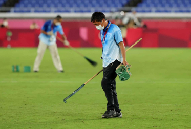 Operarios arreglan el césped tras el partido de fútbol femenino