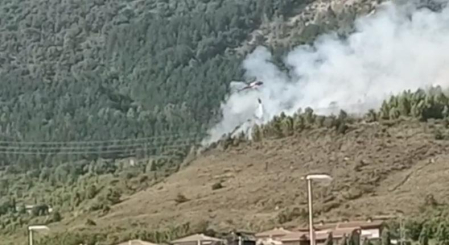 Un helicóptero lanza agua sobre las llamas del incendio del monte Ezcaba