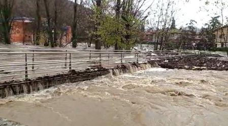 La pasarela que va las piscinas (al fondo), que habitualmente está a unos cuatro metros del agua, se ha visto superada por la riada