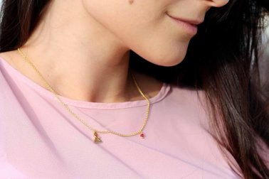 Colgante de plata dorada con una piedra roja