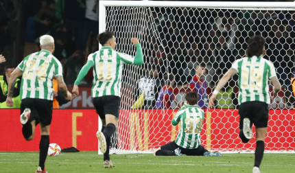 Los jugadores del Betis corren hacia Miranda, arrodillado tras anotar el decisivo encuentro que dio el título a los verdiblancos