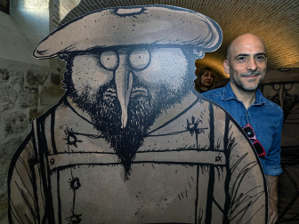 César Oroz posa en la exposición temporal 'Carliscaturas: el humor como trinchera'