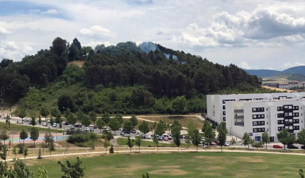 Bomberos de Navarra trabajan para extinguir un pequeño incendio registrado este lunes en una zona de bosque situada entre la nueva escuela infantil de Lezkairu y los depósitos de Mendillorri. En las labores de extinción trabaja un helicóptero.