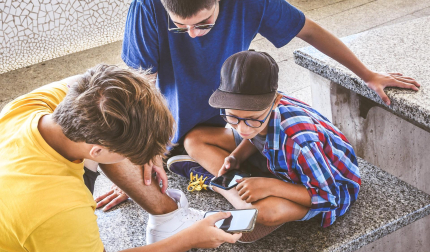 Varios adolescentes consultan el móvil