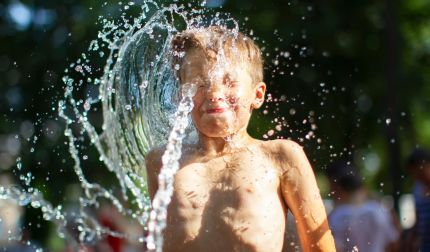 Un niño se refresca con agua en plena ola de calor