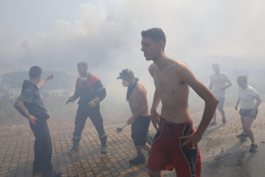 Fotos del incendio producido entre Obanos y Legarda. Vecinos de Obanos colaboran con los bomberos en la extinción del fuego en las viviendas.