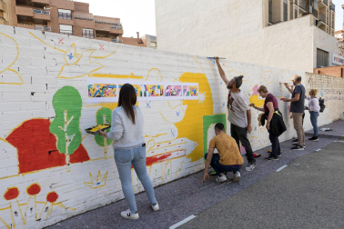 PASAJE DEL REGIO. Miembros de diversos colectivos y asociaciones de Tudela participan en la creación del mural diseñado por la artista zaragozana Arantxa Recio ‘Harsa’ en la tapia del parking ubicado en el conocido como pasaje del Regio