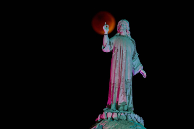 The moon and a statue are seen during a lunar eclipse in San Salvador, El Salvador, November 8, 2022. REUTERS/Jose Cabezas  LUNAR-ECLIPSE/EL SALVADOR