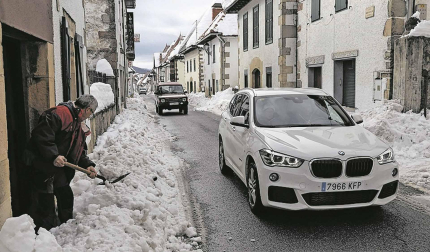 Más coches van llegando mientras los vecinos despejan la nieve en Burguete