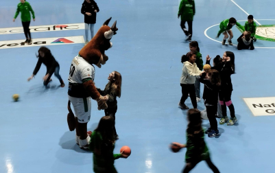 Gigi, mascota del Helvetia Anaitasuna, jugando en el descanso con algunos de los niños que saltaron a la pista