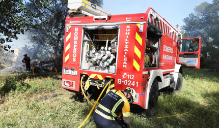 Bomberos de Navarra y agentes de la Policía Municipal de Tudela trabajan en la extinción del fuego declarado en la desembocadura del río Mediavilla