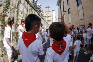 Un grupo de niños corre por delante de un toro de cartón en la Cuesta de Santo Domingo, Pamplona, durante el encierro 'txiki' que se ha celebrado este martes a mediodía y en el que, al tratar de ser lo más real posible al encierro grande, también se canta al santo y se disparan cohetes desde el corral para avisar de la salida de la manada compuesta por seis toros y tres bueyes sobre ruedas.