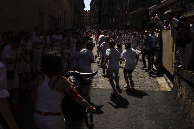 Un grupo de niños corre por delante de un toro de cartón en la Cuesta de Santo Domingo, Pamplona, durante el encierro 'txiki' que se ha celebrado este martes a mediodía y en el que, al tratar de ser lo más real posible al encierro grande, también se canta al santo y se disparan cohetes desde el corral para avisar de la salida de la manada compuesta por seis toros y tres bueyes sobre ruedas.