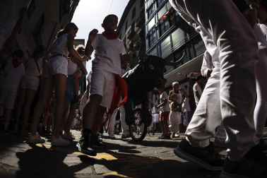 Un grupo de niños corre por delante de un toro de cartón en la Cuesta de Santo Domingo, Pamplona, durante el encierro 'txiki' que se ha celebrado este martes a mediodía y en el que, al tratar de ser lo más real posible al encierro grande, también se canta al santo y se disparan cohetes desde el corral para avisar de la salida de la manada compuesta por seis toros y tres bueyes sobre ruedas.