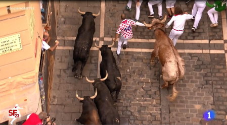 Un manso empuja a un mozo y lo coloca entre dos toros en Estafeta