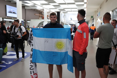 El aficionado que ha acudido a saludar al Chimy Ávila posa con la bandera argentina firmada
