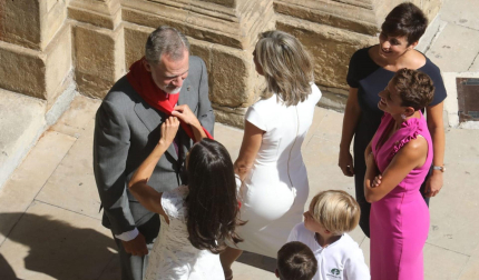 Momento en el que la reina Letizia coloca al rey Felipe VI uno de los pañuelos rojos que unos niños le habían obsequiado en la puerta del Ayuntamiento de Pamplona