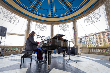 Fotos de personas tocando el piano de cola instalado en el kiosco de la Plaza del Castillo de Pamplona. /