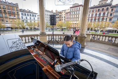 Fotos de personas tocando el piano de cola instalado en el kiosco de la Plaza del Castillo de Pamplona. /