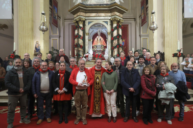 Los integrantes de la asociación posan junto al párroco tras concluir una misa de menos de una hora