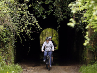 Dos cicloturistas atraviesan un túnel de la Vía Verde del Plazaola.